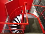 a red spiral staircase going up to the top of a building
