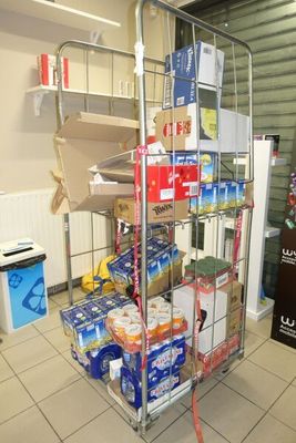 un chariot métallique chargé de nombreux objets, dans une pièce