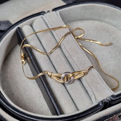 un bracelet en or et en argent dans un écrin noir