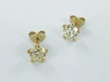 une paire de boucles d'oreilles en diamant sur une surface blanche