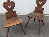 pair of antique wooden chairs with carved backrests in the shape of hearts