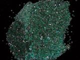 a pile of green crushed glass on a black surface