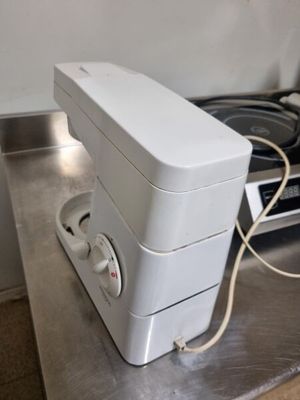 a white toaster sitting on a counter top next to a stove