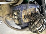 une machine bleue posée par terre à côté d'un enchevêtrement de fils