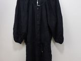 the black dress is hanging on a hanger against a wall
