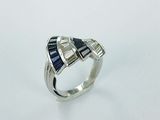 a close up of a ring with blue and white stones on it