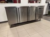 a stainless steel refrigerator in the middle of a tiled floor