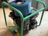 un chariot vert surmonté d'un tuyau bleu
