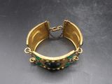 Gros plan sur une bague en or ornée de pierres vertes