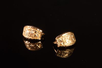 deux bagues en or sur un fond noir, avec un reflet