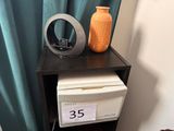 a small table with a clock on it and a vase on it