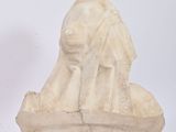 a statue of a woman sitting on a rock next to a statue of an elephant