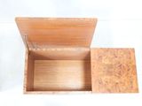 a small wooden box that is open on a white surface