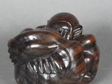une image représentant une sculpture en bois d'un singe tenant un bébé dans ses bras