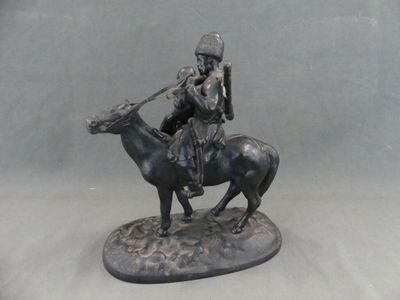 une statue représentant un homme à cheval accompagné d'un chien
