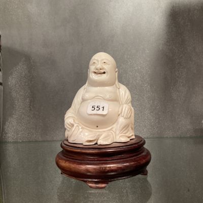 une statue de Bouddha blanche posée sur une table en verre
