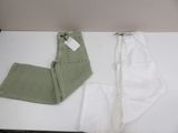 a pair of white pants and a pair of green pants on a table