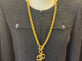 a mannequin mannequin with a gold chain and an anchor pendant