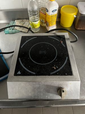 a stove top with a black burner on it in a kitchen