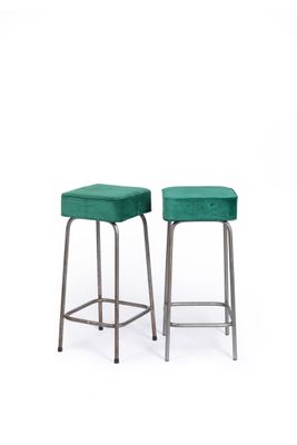 two green stools sitting next to each other on a white surface
