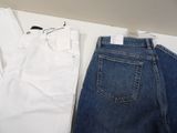 two pairs of white and blue jeans sitting on a white table