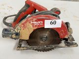 une scie circulaire rouge posée sur une table blanche