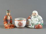 deux figurines de bouddhas assis à côté d'un bol et d'un vase