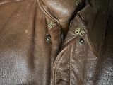 a close up of a brown leather jacket with buttons on it
