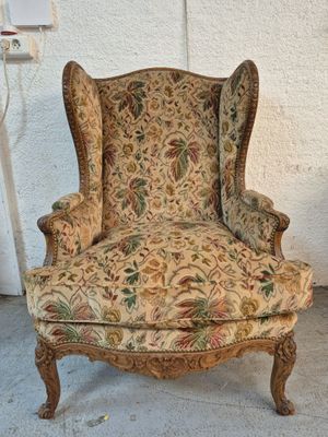 an old chair with a floral upholstered back