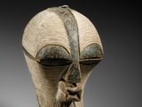 une photo en gros plan d'un masque en bois posé sur une table