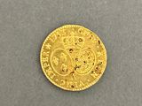 a close up of a gold coin on a gray surface