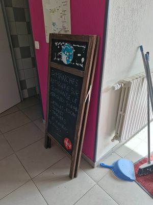 a blackboard with writing on it in the corner of a room