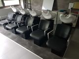 a row of chairs with sinks in the middle of the room