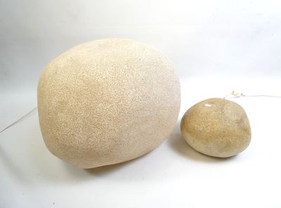 a large stone and a small stone on a white surface
