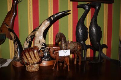 une sculpture en bois représentant un oiseau, une girafe, un cheval et une girafe, posée sur une table