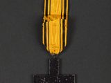 a yellow and black medal with a cross on it