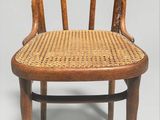 une vieille chaise en bois avec un dossier et une assise en rotin