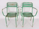 pair of green metal garden chairs with arms and backrests