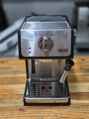 a small coffee maker sitting on a wooden table