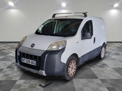 une camionnette blanche garée sur un sol en damier