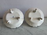 two white vases sitting on a marble counter top