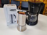 a coffee maker sitting on a table next to a box of coffee