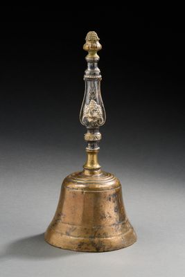 une vieille cloche en laiton surmontée d'un oiseau
