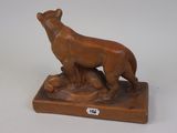 an image of a statue of a dog on a wooden base