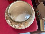 a bowl sitting on a red table with a box next to it