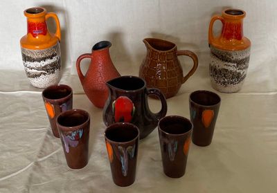 many different colored vases and cups on the table