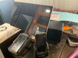 une photo d'un bureau encombré sur lequel se trouvent un ordinateur portable et un téléphone portable