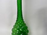 a green glass vase sitting next to a green glass bowl