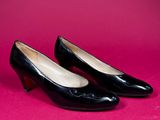 pair of black shoes on a pink background