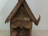 a small wooden house with horns on top of it
